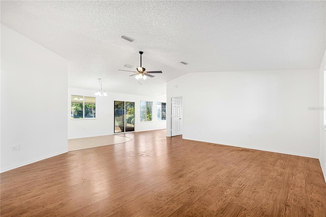 spare room with wood-type flooring, ceiling fan with notable chandelier, a textured ceiling, and lofted ceiling