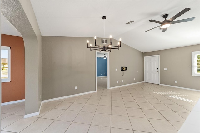 tiled spare room featuring ceiling fan with notable chandelier and vaulted ceiling