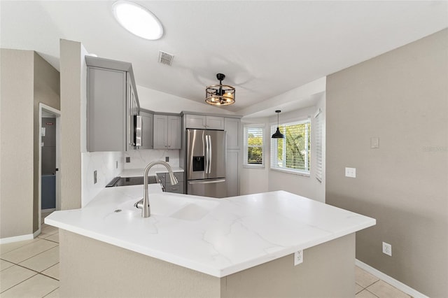 kitchen featuring gray cabinetry, pendant lighting, sink, appliances with stainless steel finishes, and kitchen peninsula