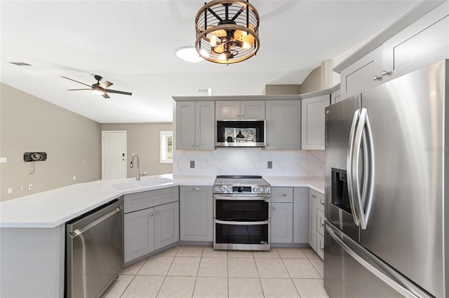 kitchen with gray cabinetry, ceiling fan, light tile patterned floors, and stainless steel appliances