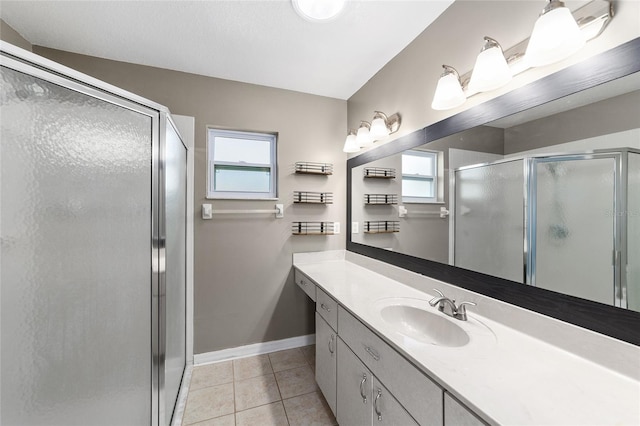 bathroom featuring tile patterned floors, plenty of natural light, vanity, and a shower with shower door