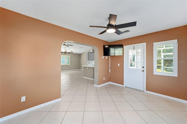 interior space featuring light tile patterned floors, ceiling fan, lofted ceiling, and sink