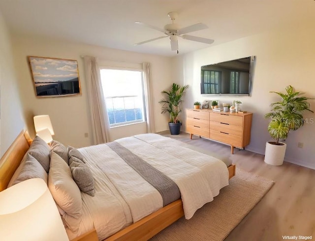 bedroom with light hardwood / wood-style floors and ceiling fan