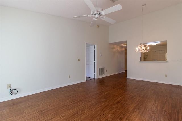 spare room featuring dark hardwood / wood-style floors, ceiling fan with notable chandelier, and high vaulted ceiling