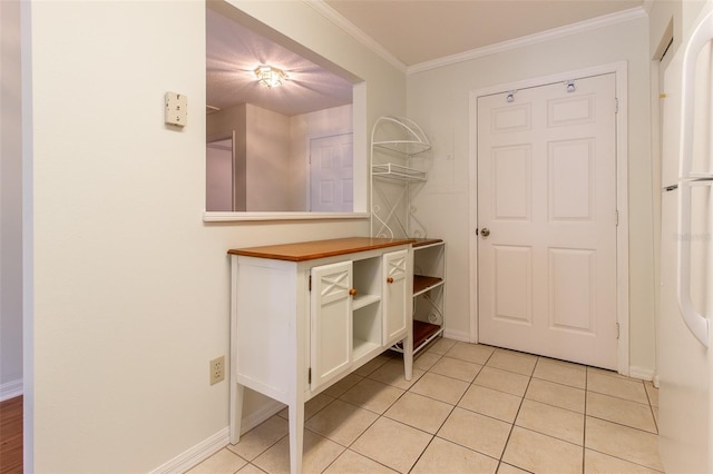 interior space with ornamental molding and light tile patterned floors