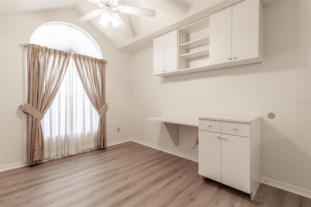 interior space with ceiling fan, vaulted ceiling, and light wood-type flooring