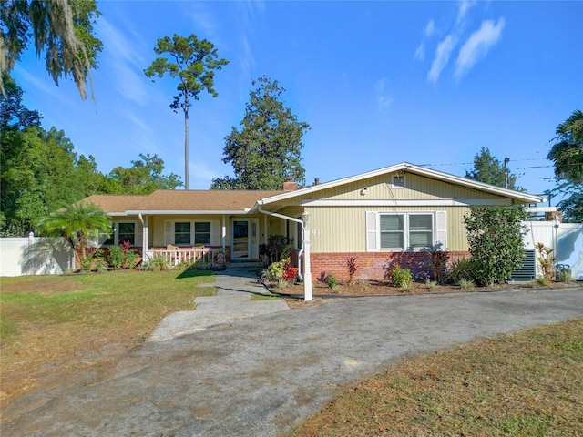 single story home featuring a front lawn and covered porch