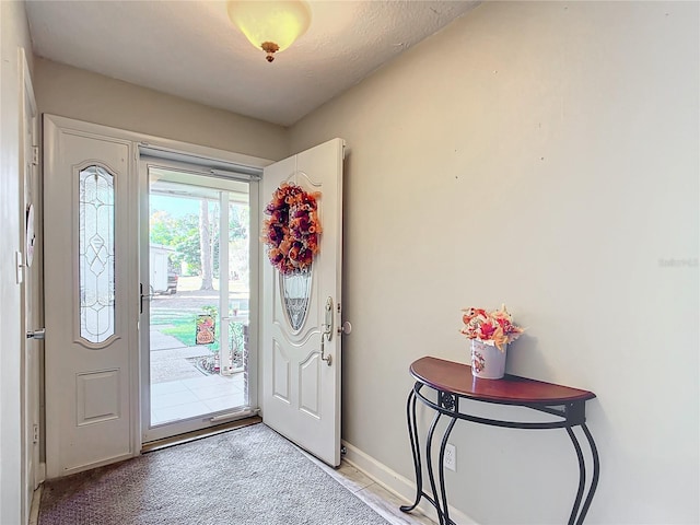 foyer entrance featuring light colored carpet