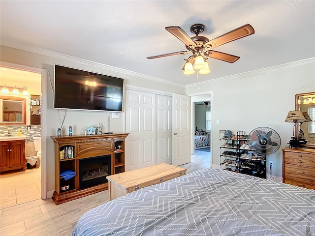 bedroom featuring ensuite bath, ceiling fan, a closet, and ornamental molding