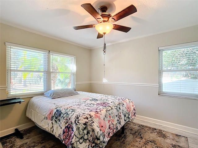 bedroom with ceiling fan, crown molding, and multiple windows