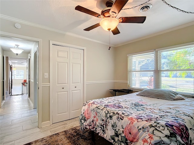 bedroom with a closet, light hardwood / wood-style flooring, ceiling fan, and ornamental molding