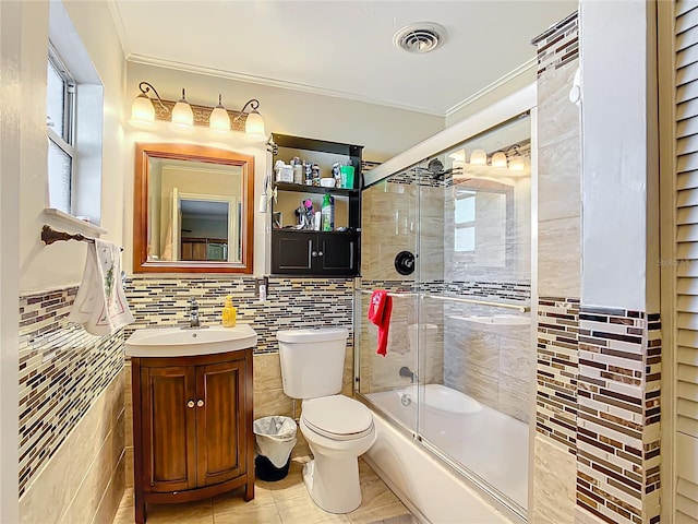 full bathroom with vanity, crown molding, toilet, enclosed tub / shower combo, and tile walls