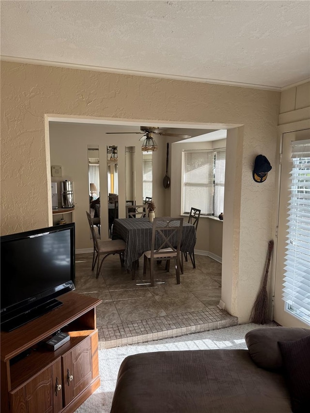 dining area featuring ceiling fan and a textured ceiling