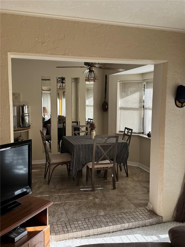 dining area featuring ceiling fan and tile patterned flooring