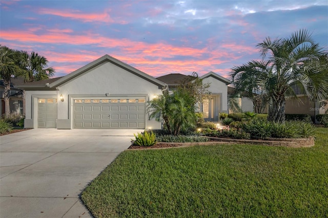 ranch-style house featuring a lawn and a garage