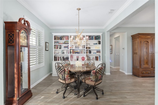 dining space featuring wood-type flooring, a notable chandelier, and ornamental molding