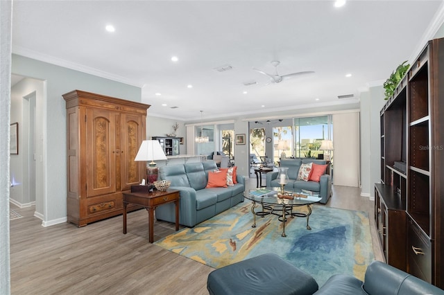 living room with light wood-type flooring, ceiling fan, and ornamental molding