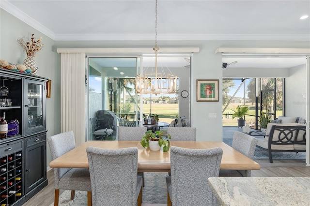 dining room featuring a chandelier, light wood-type flooring, and ornamental molding