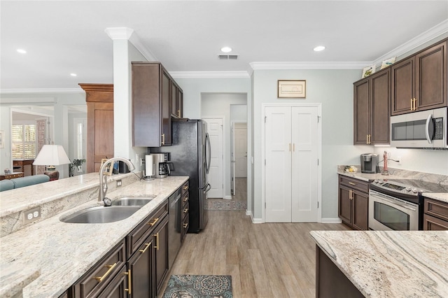 kitchen featuring sink, light stone counters, light hardwood / wood-style floors, appliances with stainless steel finishes, and ornamental molding