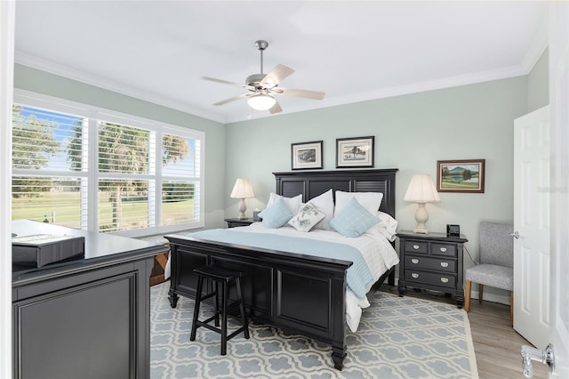 bedroom featuring ceiling fan, crown molding, and light hardwood / wood-style flooring