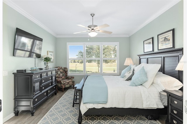 bedroom featuring dark hardwood / wood-style floors, ceiling fan, and ornamental molding