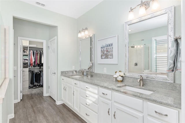 bathroom with vanity, hardwood / wood-style flooring, and walk in shower