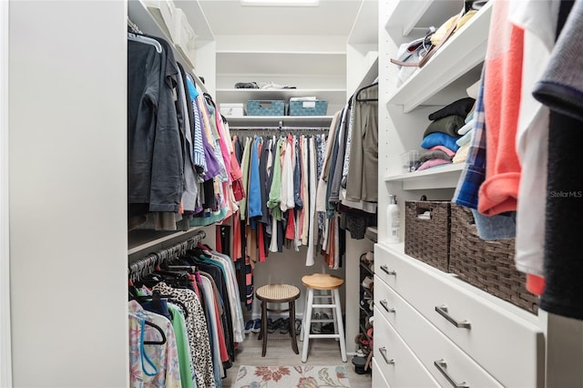 walk in closet with light hardwood / wood-style floors