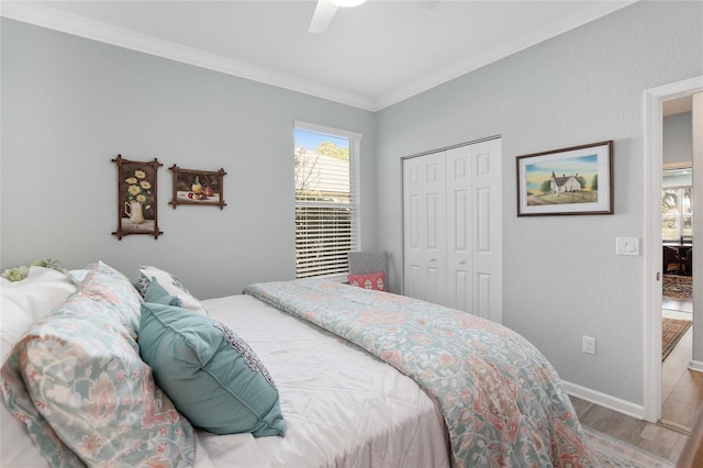 bedroom featuring hardwood / wood-style floors, a closet, ceiling fan, and ornamental molding