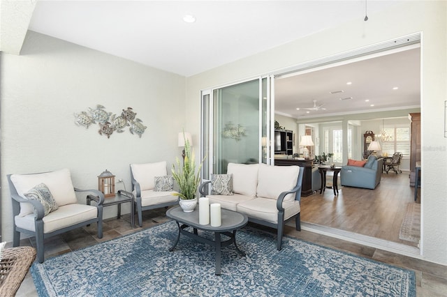 living room featuring hardwood / wood-style flooring, ceiling fan, and crown molding