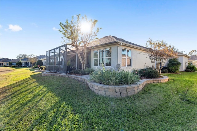 back of property with a lanai and a yard