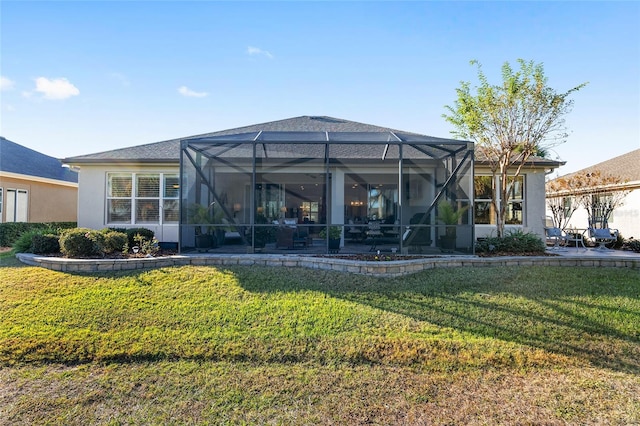 rear view of property with glass enclosure and a yard