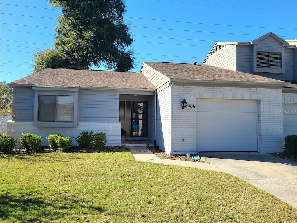 view of front of home with a front yard and a garage