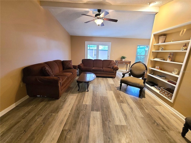 living room featuring a textured ceiling, hardwood / wood-style flooring, ceiling fan, and lofted ceiling