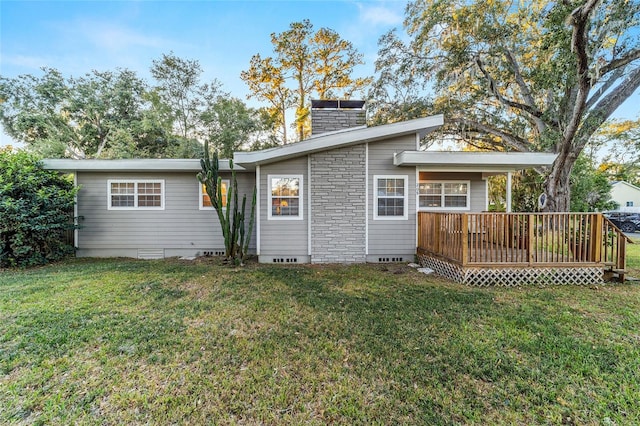 rear view of house with a wooden deck and a yard