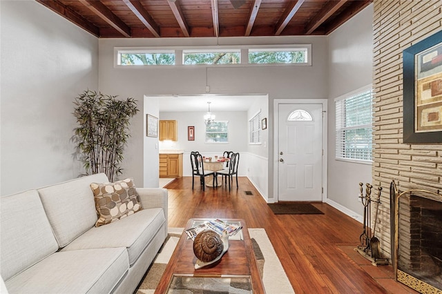 living room with dark hardwood / wood-style floors, a healthy amount of sunlight, wooden ceiling, and a fireplace