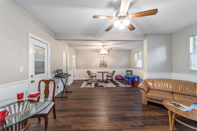 living room featuring ceiling fan and dark hardwood / wood-style flooring