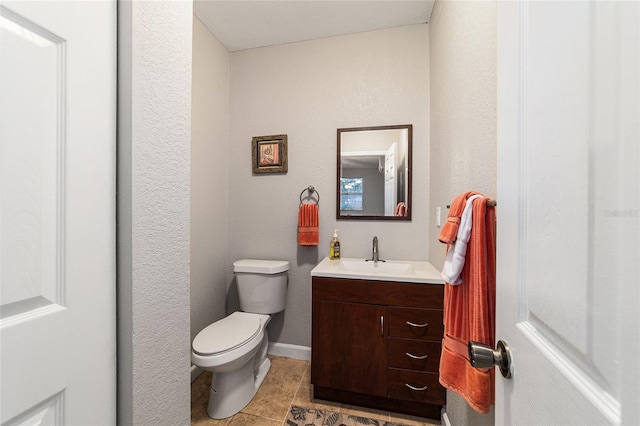 bathroom featuring tile patterned flooring, vanity, and toilet