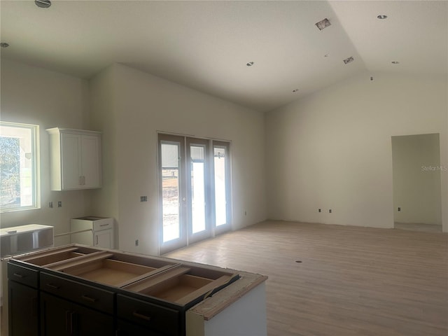 kitchen featuring a wealth of natural light, light wood-type flooring, a kitchen island, and white cabinets