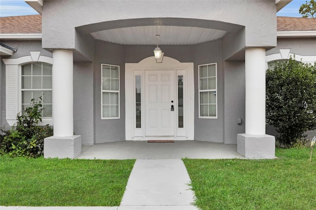 property entrance featuring a lawn