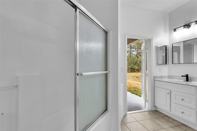 bathroom featuring tile patterned flooring, vanity, and a shower with door