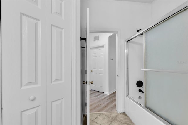 bathroom featuring shower / bath combination with glass door and wood-type flooring