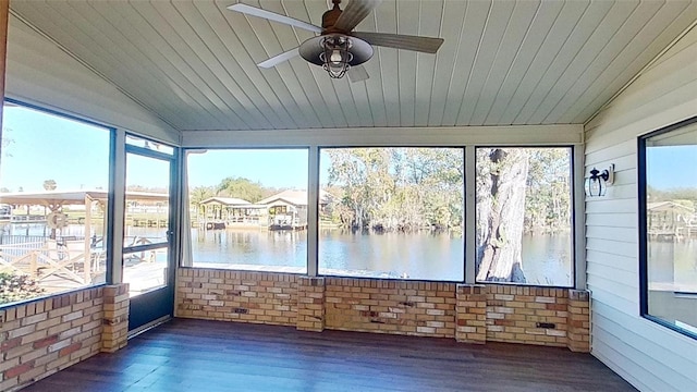 unfurnished sunroom featuring a water view, a wealth of natural light, lofted ceiling, and ceiling fan