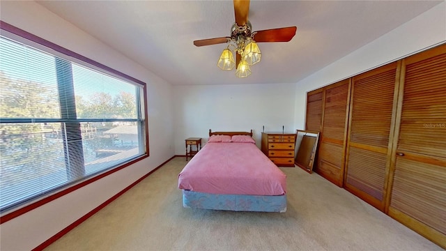 carpeted bedroom with a closet and ceiling fan