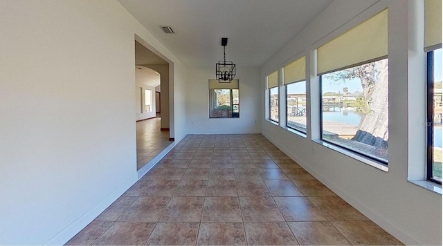 interior space featuring a water view and an inviting chandelier