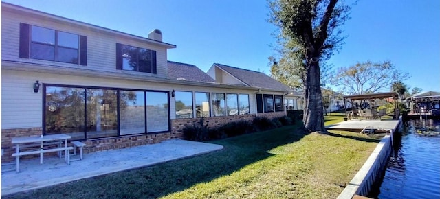 rear view of property featuring a lawn and a patio