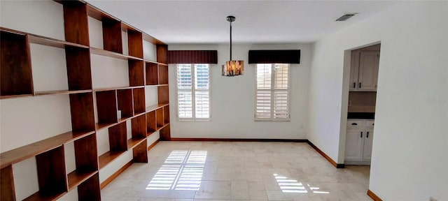 unfurnished dining area with light tile patterned flooring and a notable chandelier