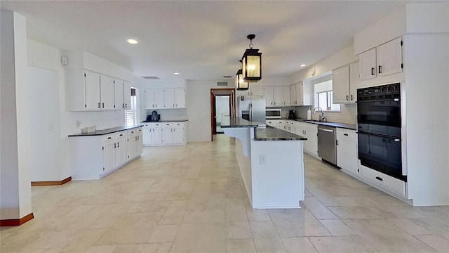 kitchen featuring white cabinetry, a kitchen island, stainless steel appliances, and sink