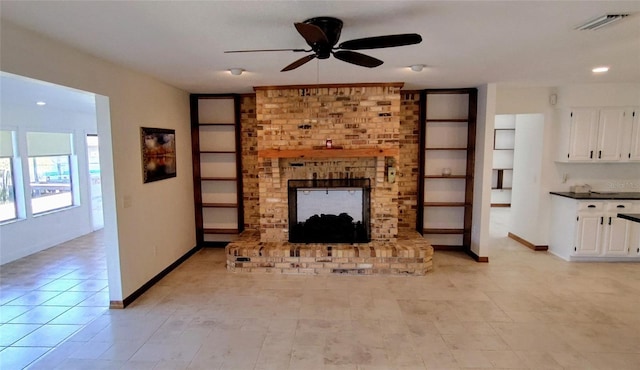 unfurnished living room with ceiling fan and a brick fireplace