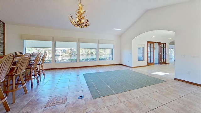 interior space featuring a chandelier, light tile patterned floors, and lofted ceiling