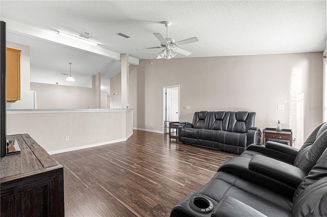 living room with a textured ceiling, dark hardwood / wood-style flooring, vaulted ceiling, and ceiling fan